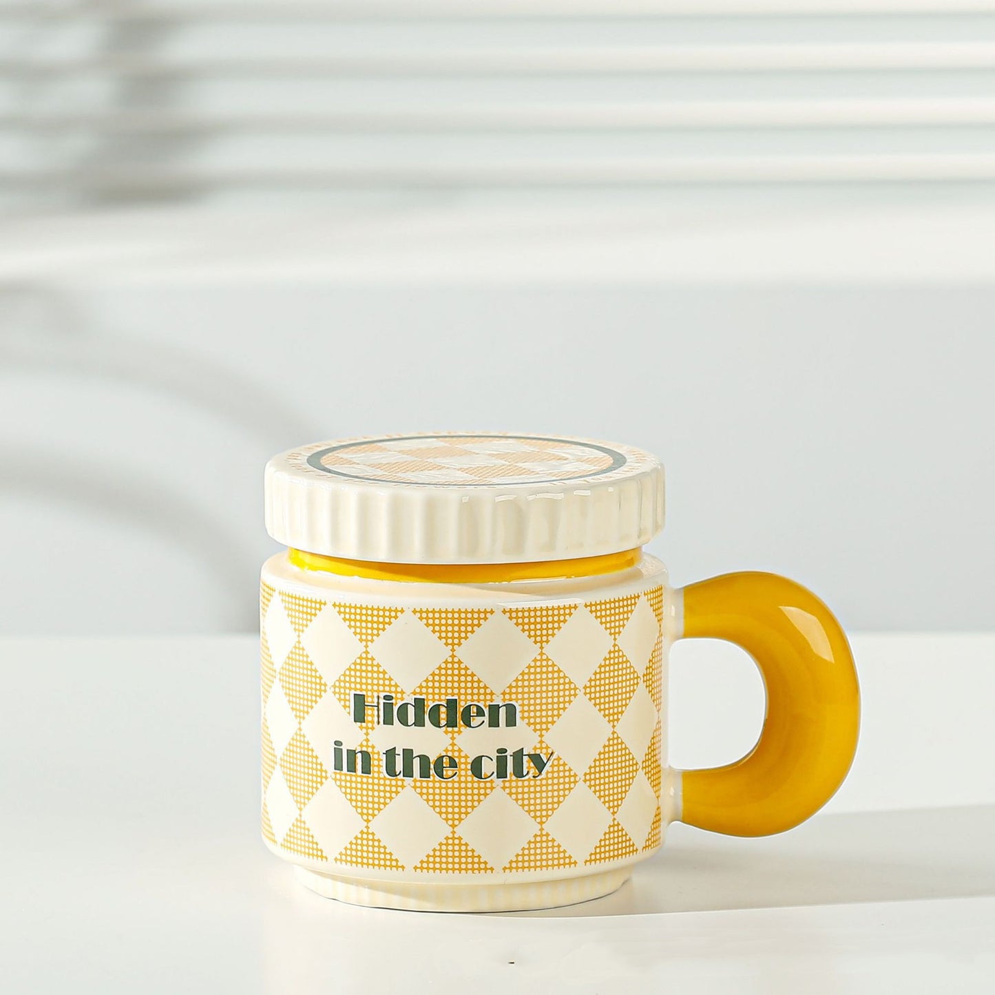 Yellow ceramic cup with grid pattern and lid